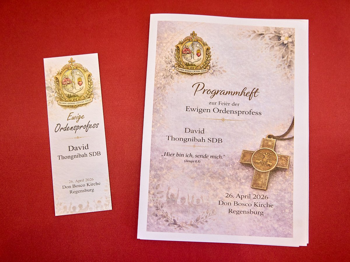 Ein Programmheft und Lesezeichen zur Ewigen Ordensprofess von David Thongnibah SDB am 26. April 2026 in Regensburg auf rotem Grund.
