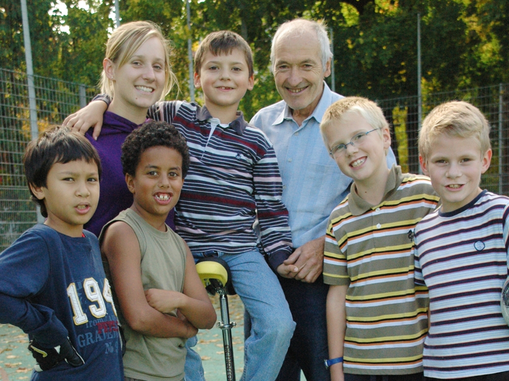 Glückliche, generationenübergreifende Gruppe aus einer Frau, einem Mann und fünf Jungen im Freien.
